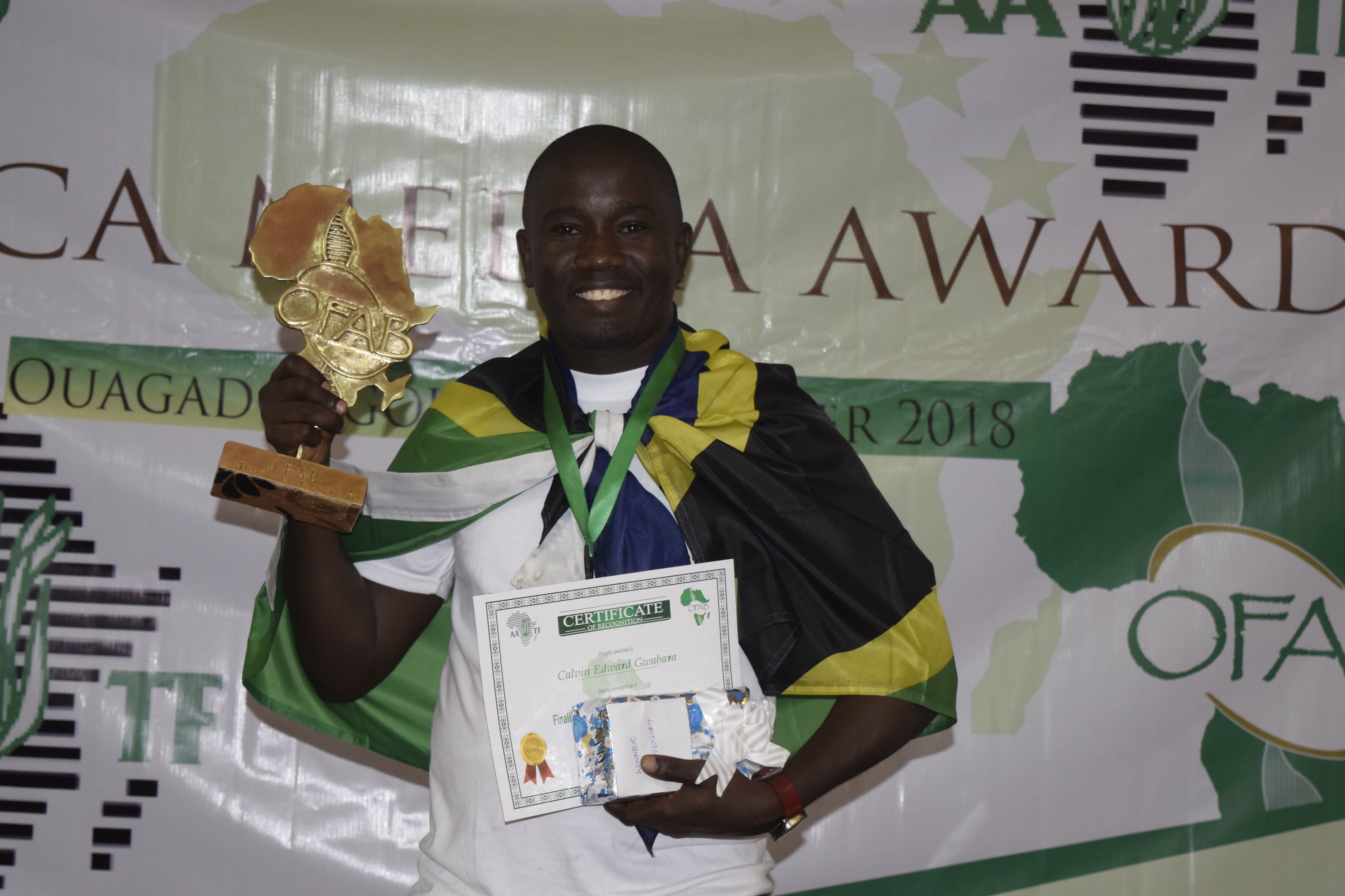 Mr Calvin Gwabara Displaying Awards and Certificates after emerged the winner of the Open Forum on Agriculture Biotechnology (OFAB) Africa Media Awards, 2018.